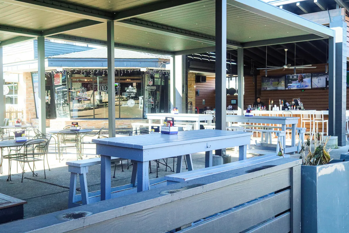 An exterior shot of an outdoor seating area featuring a bar counter and decorative lights. The scene evokes a relaxed yet lively ambiance that's ideal for socializing, enjoying drinks, or celebrating with friends—key aspects of a night out in Park Circle.